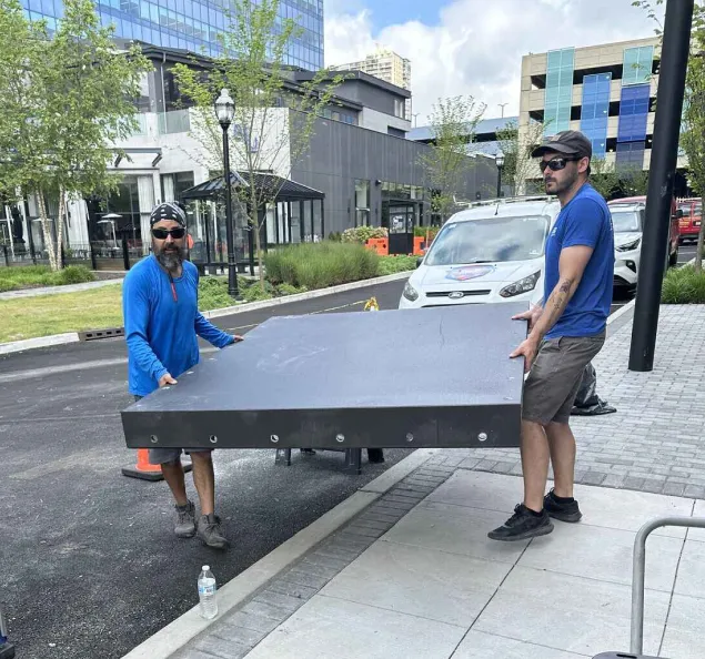 FRA flood experts carrying a custom flood panel on-site